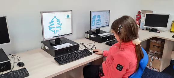Dziecko siedzące przed ekranem komputera z oprogramowaniem do druku 3D